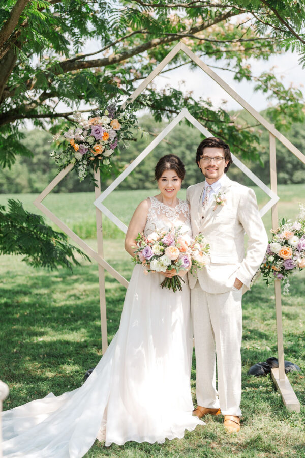 photo of couple in front of diamond wedding arch