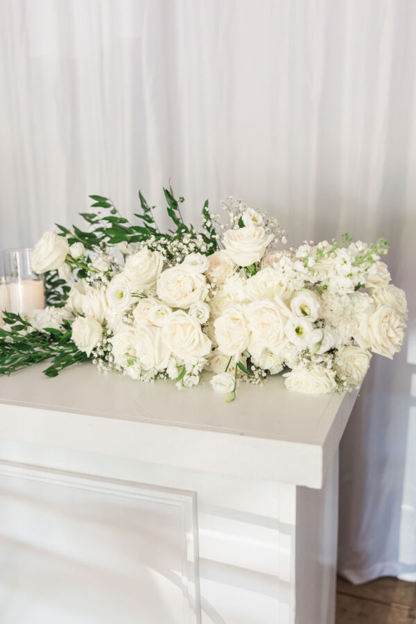 Close up image of white flowers on white bar with pillar rental