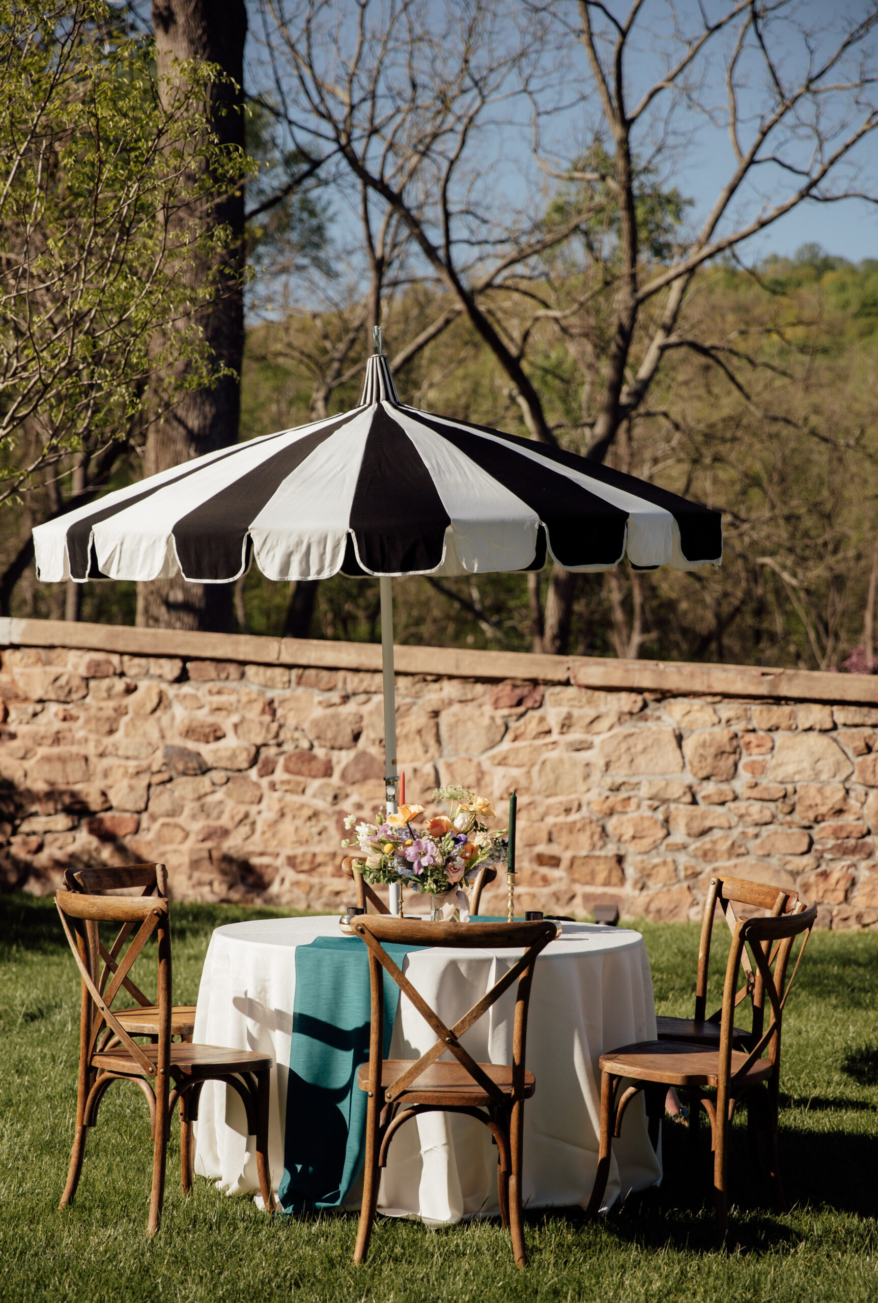 Image of crossback chairs and table with umbrella in courtyard