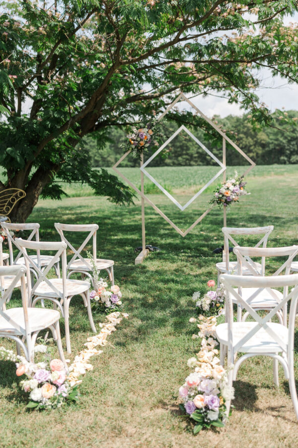 image of white washed cross back chair rentals set for wedding ceremony