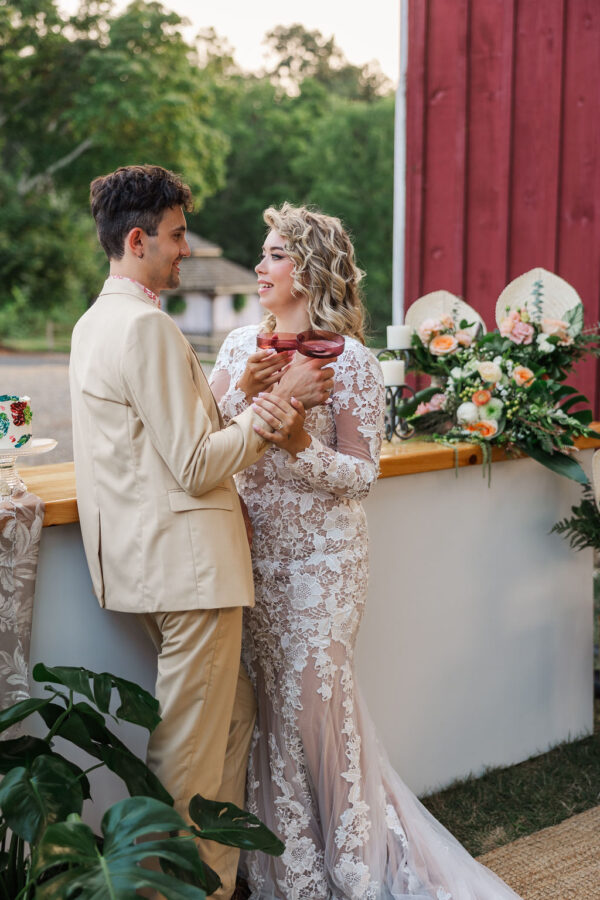 image of couple holding red fluted champagne glasses