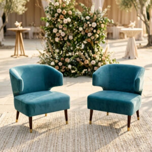 two teal velvet accent chairs arranged as a conversational setting for a cocktail hour at a wedding.