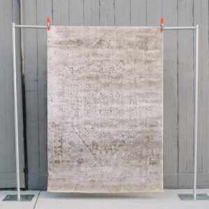 image of Birdie rug against a grey barn wall