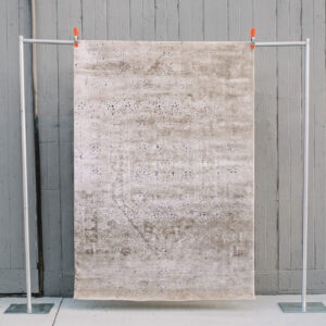 image of Birdie rug against a grey barn wall