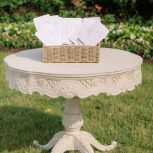 White decorative side table with wedding cards on display.