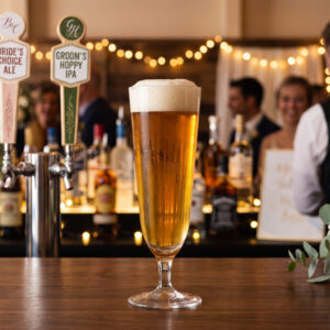 fluted pilsner glass with beer at a bar setting