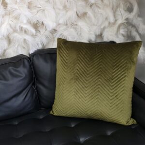 Olive green pillow with zigzag stitching.