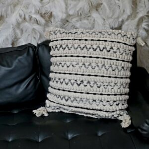 Black and white throw pillow with zig zag pattern and frills.