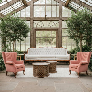 Lounge setting featuring the Vintage white Clarece couch, two pink velvet Molly armchairs, modern wood Willa coffe table/side table, modern gold Blanche side tables, and Ivory patterned Britton Rug.