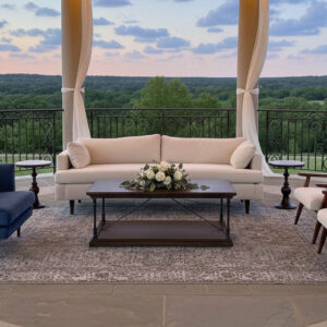 Lounge setting containing the white velvet Crane sofa, two white Frankie armchairs, blue velvet Brooklyn armchair, two mahogany Lincoln side tables, wooden Jefferson coffee table, and Bluebell accent rug.