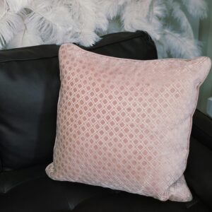 Large, light pink throw pillow with small diamond print design.