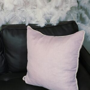 Light pink throw pillow with white trim.