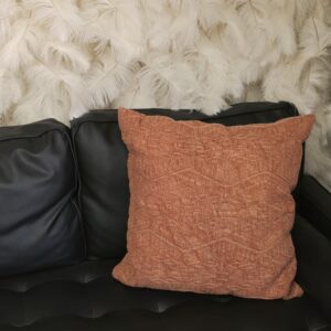 Burnt orange throw pillow with small aztec print desgins
