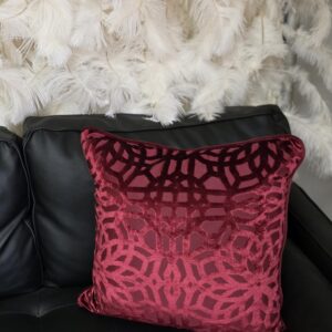 Deep red pillow with floral and circular designs.