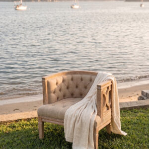 AI generated image of the Lucia Accent Chair rental staged in an intimate coastal setting.