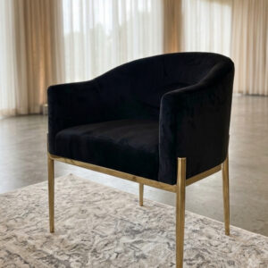 AI generated photo of a black velvet chair with gold trim and legs staged in a wedding reception setting.